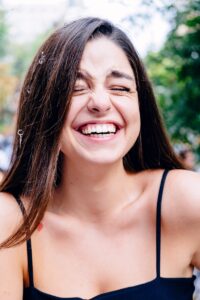 femme en haut noir à bretelles spaghetti souriante
